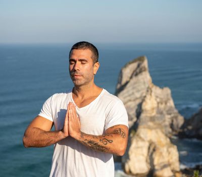 Man breathing deeply with closed eyes before starting a workout.